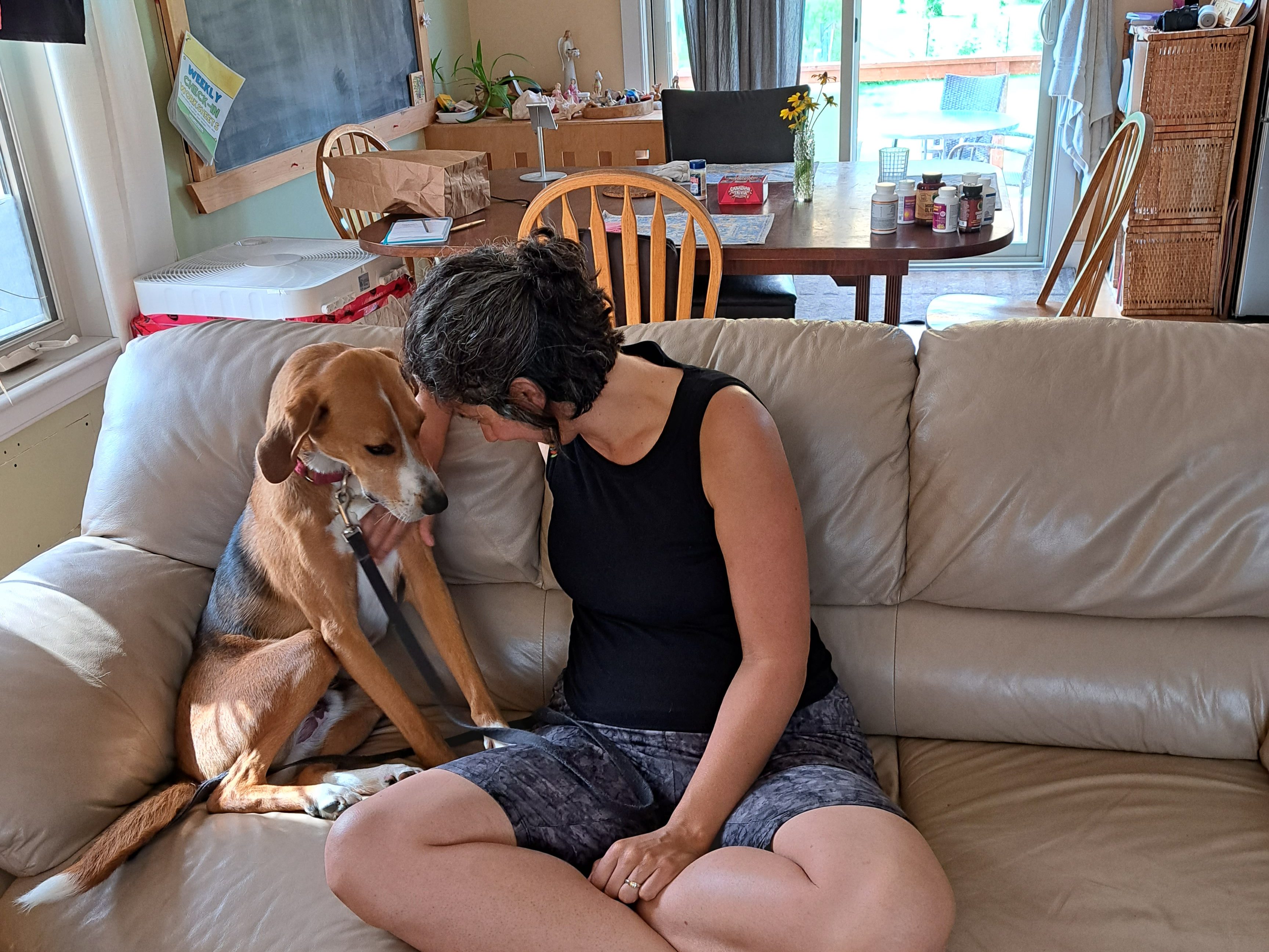 Bradlee and her dog Archie, facing each other on the couch and touching heads.