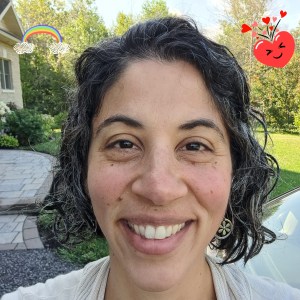 Picture of author smiling with hearts and rainbow stickers.