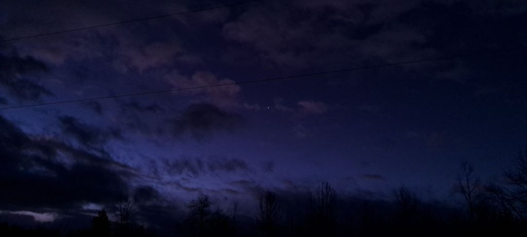 Dark, early morning sky, with a few stars and clouds
