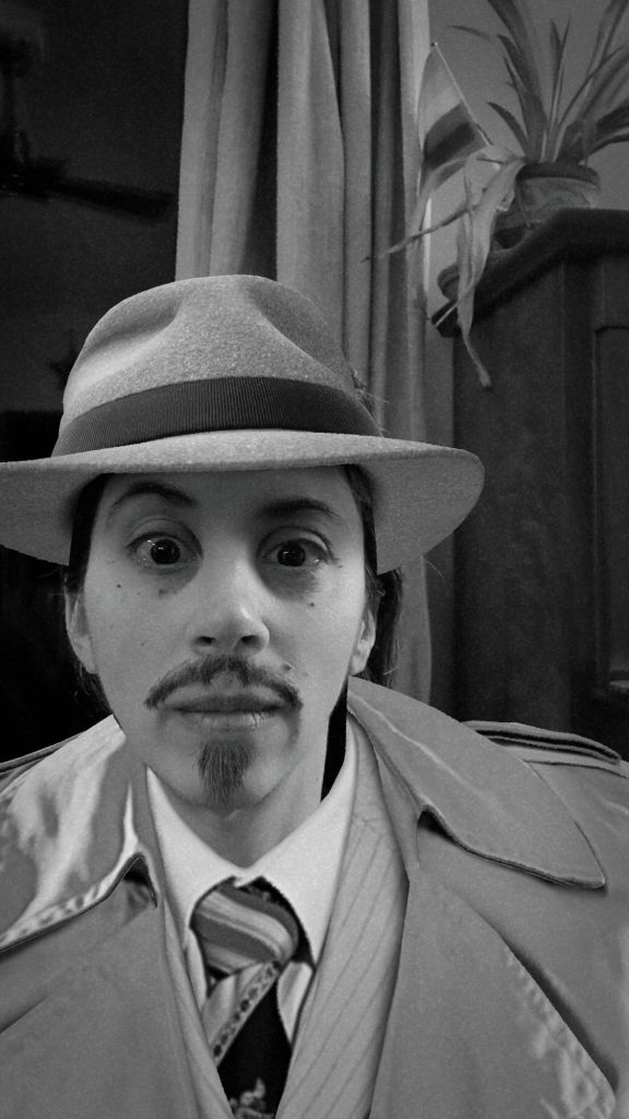 Bradlee with a fake mustache, detective hat and trench coat