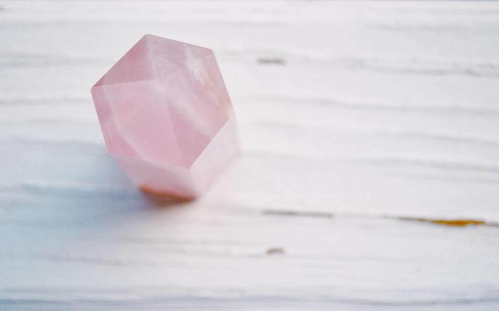 A rose quartz on a marble table.