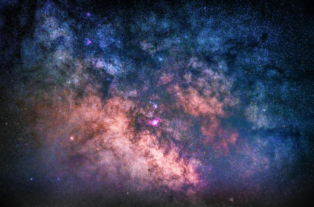 A photo in space, of pink and dark purple matter, with darkness all around.