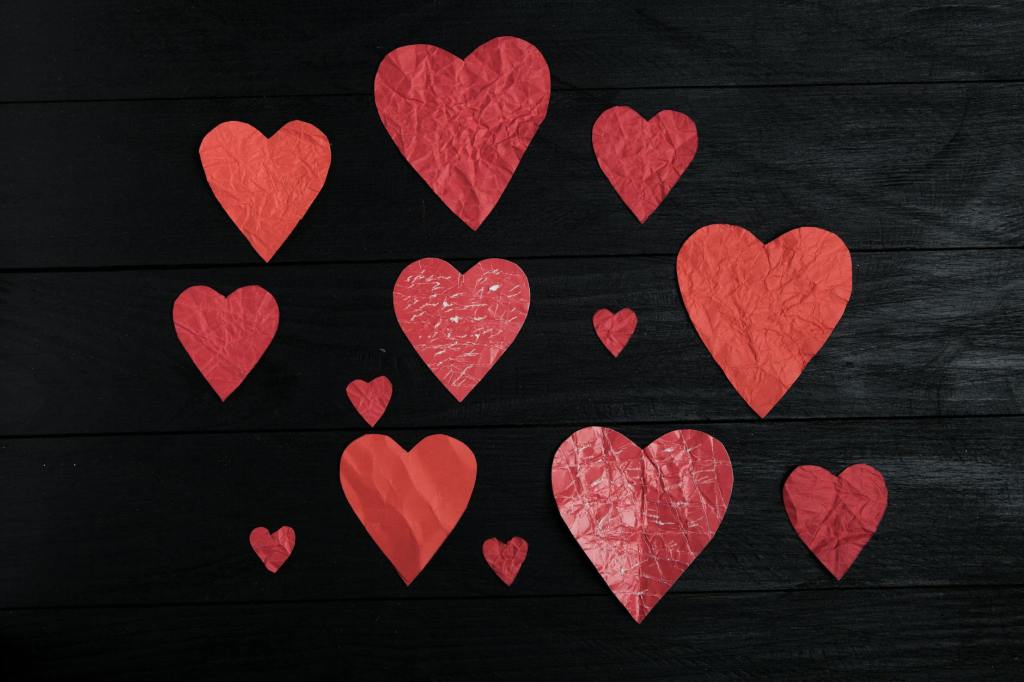 Red hearts of different sizes on a black background