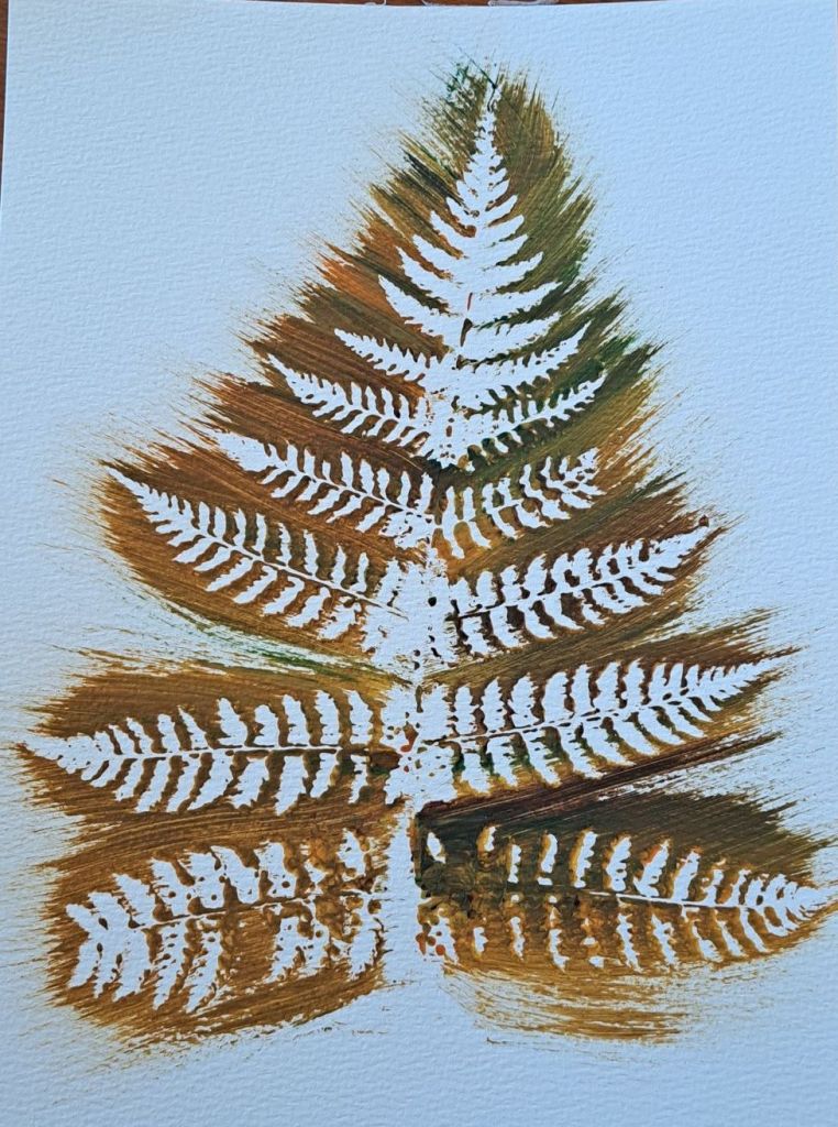 an orange, brown, yellow and green outline of a fern.