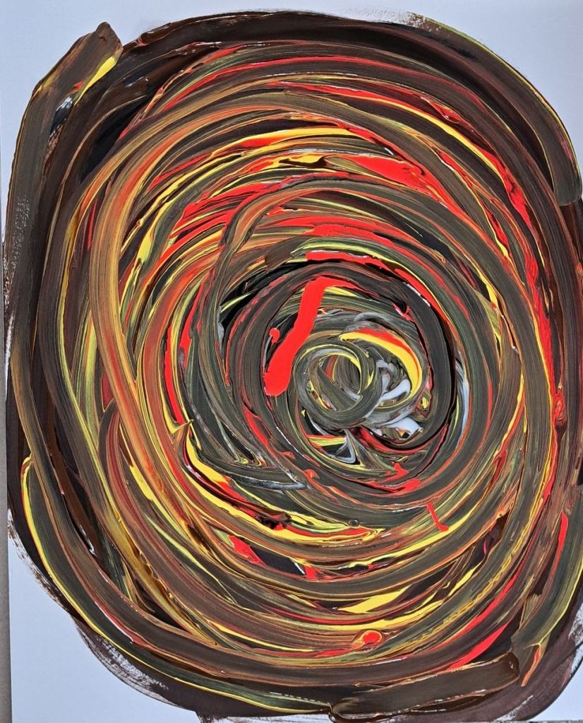 Swirls of color in a circular pattern.  The colors include pink, yellow, white, brown and black.